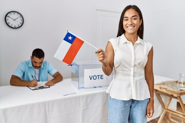 Young chilean voter woman holding chile flag at electoral college.