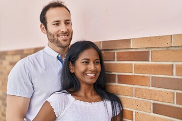 Man and woman interracial couple standing together at street