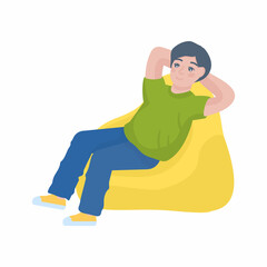 Boy wearing green t-shirt sits in bag chair stretch hands isolated on plain yellow background. Lifestyle concept.
