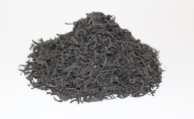 Black tea leaves heap on the white background