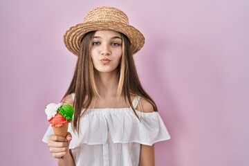 Teenager girl holding ice cream looking at the camera blowing a kiss on air being lovely and sexy. love expression.
