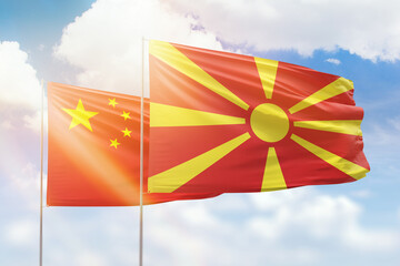 Sunny blue sky and flags of north macedonia and china