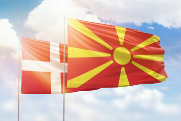 Sunny blue sky and flags of north macedonia and denmark