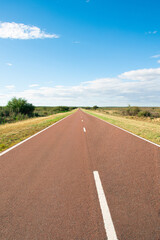 A long straight road leading to nowhere in a rural landscape