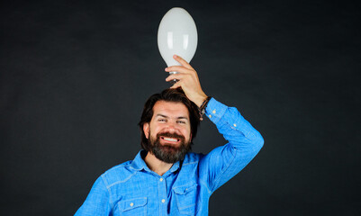 Good idea. Handsome bearded man in denim shirt with light bulb. Energy and electricity.