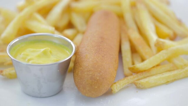Dipping Corn Dog into Mustard