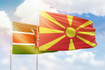 Sunny blue sky and flags of north macedonia and kenya