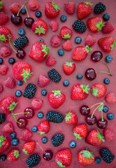 seasonal berries and cherry on a red background  