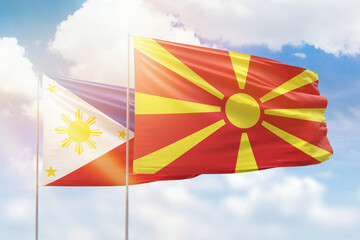 Sunny blue sky and flags of north macedonia and philippines