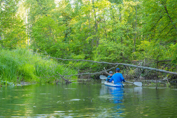 A group of three people paddle in a kayak. Rafting on the fast river. Adventure traveling lifestyle. Concept wanderlust. Active weekend vacations wild nature outdoor.