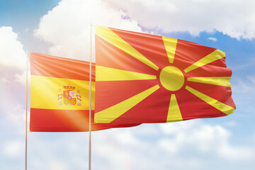 Sunny blue sky and flags of north macedonia and spain
