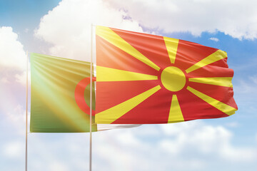 Sunny blue sky and flags of north macedonia and algeria