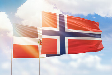 Sunny blue sky and flags of norway and dominican republic