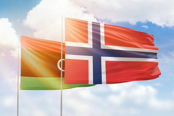 Sunny blue sky and flags of norway and libya