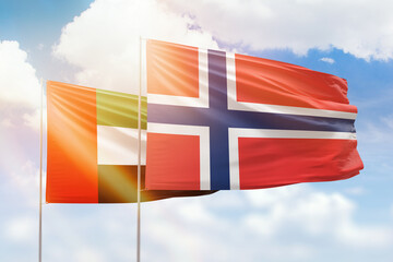 Sunny blue sky and flags of norway and uae