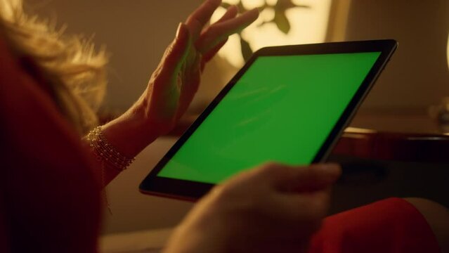 Passenger using green tablet in private jet. Hands scroll chroma key pad closeup