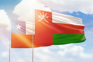 Sunny blue sky and flags of oman and chile