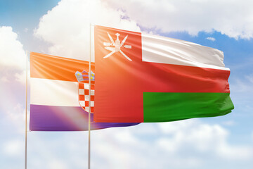 Sunny blue sky and flags of oman and croatia