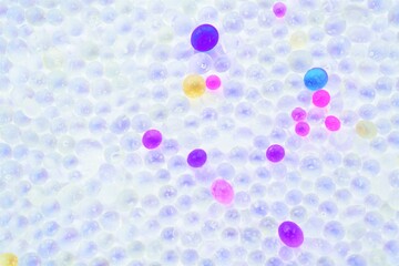 一面の乾燥剤として使われるビーズ状の透明のシリカゲルとピンクや青の塩化コバルトで着色されたシリカ