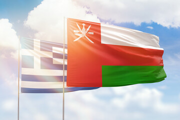 Sunny blue sky and flags of oman and greece