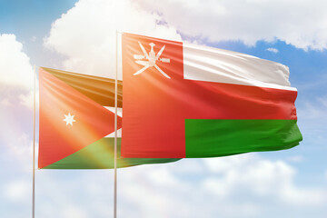 Sunny blue sky and flags of oman and jordan