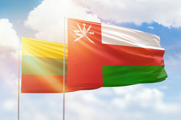 Sunny blue sky and flags of oman and lithuania