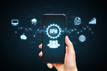 Concept BPM or Business process management. Business acronym. Holographic icons by the phone in the hands of a person