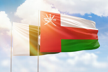 Sunny blue sky and flags of oman and pakistan