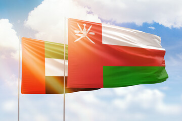 Sunny blue sky and flags of oman and uae - obrazy, fototapety, plakaty