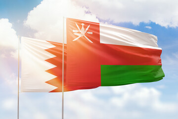 Sunny blue sky and flags of oman and bahrain