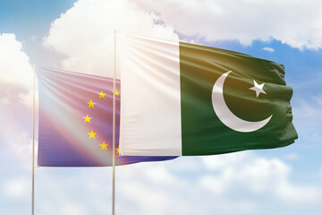 Sunny blue sky and flags of pakistan and european union