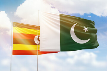 Sunny blue sky and flags of pakistan and uganda