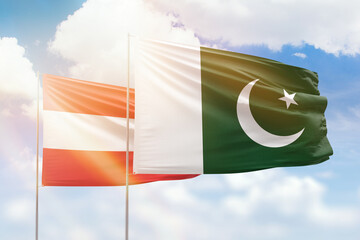 Sunny blue sky and flags of pakistan and austria