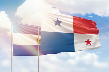 Sunny blue sky and flags of panama and el salvador