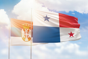 Sunny blue sky and flags of panama and serbia