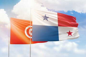 Sunny blue sky and flags of panama and tunisia