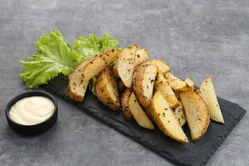 Roasted potato wedges with rosemary and herbs, served with chili sauce
