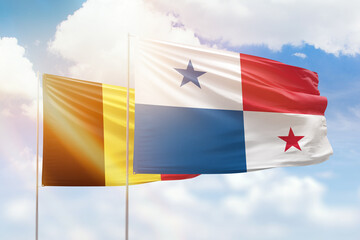 Sunny blue sky and flags of panama and belgium