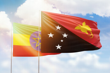 Sunny blue sky and flags of papua new guinea and ethiopia
