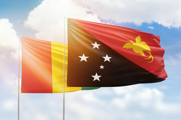 Sunny blue sky and flags of papua new guinea and guinea