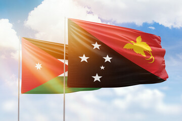 Sunny blue sky and flags of papua new guinea and jordan