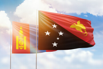 Sunny blue sky and flags of papua new guinea and mongolia