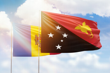 Sunny blue sky and flags of papua new guinea and moldova