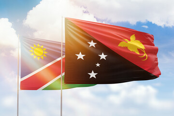 Sunny blue sky and flags of papua new guinea and namibia