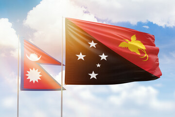 Sunny blue sky and flags of papua new guinea and nepal