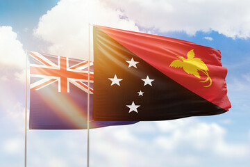 Sunny blue sky and flags of papua new guinea and new zealand