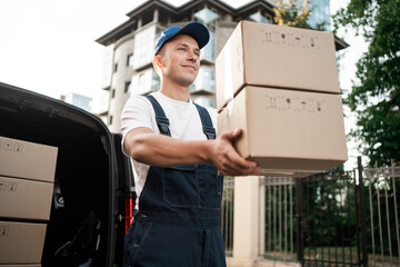 The employee driver of the courier company will deliver the goods in boxes to your home, in uniform...