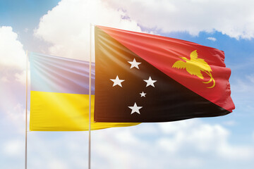 Sunny blue sky and flags of papua new guinea and ukraine