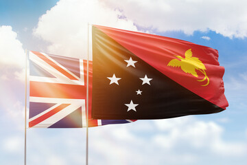 Sunny blue sky and flags of papua new guinea and united kingdom