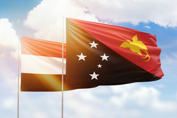 Sunny blue sky and flags of papua new guinea and yemen